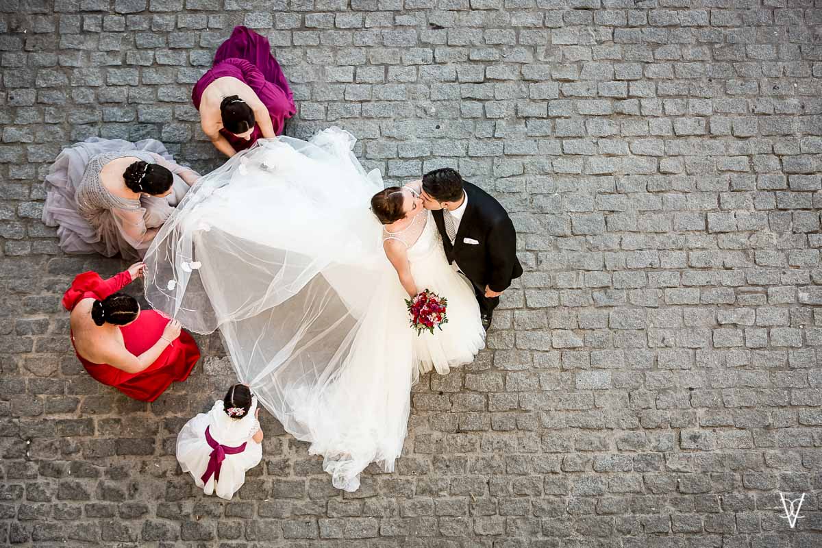 Fotos de boda en Sevilla Beso de novios y arreglos del traje de novia